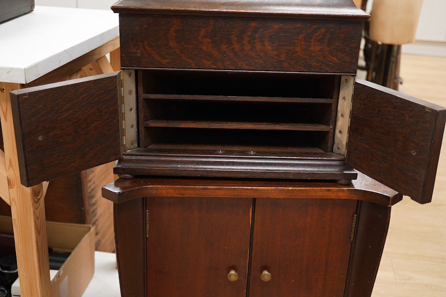 Two gramophone players; an oak cased HMV tabletop gramophone on a similar style mahogany gramophone record stand, height of stand 72.5cm, together with a May-Fair Deluxe Model portable gramophone player. Condition - poor